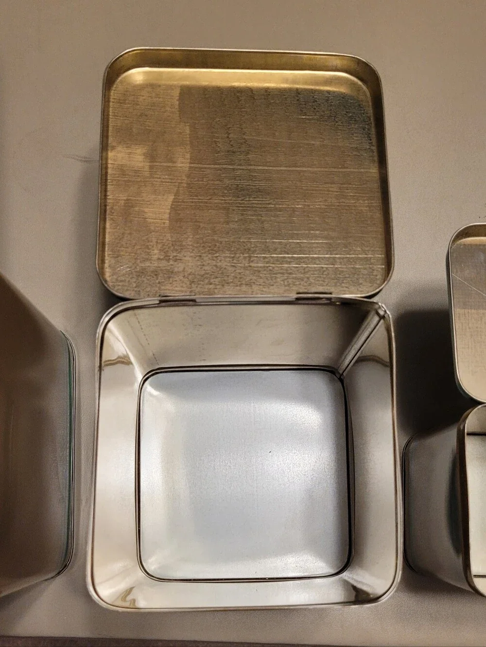LASLO - Set of 3 Nesting Tan Metal Canisters with Green Lids and Stripes.